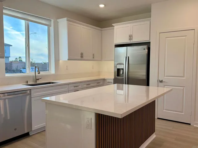 a kitchen with a sink a refrigerator and cabinets