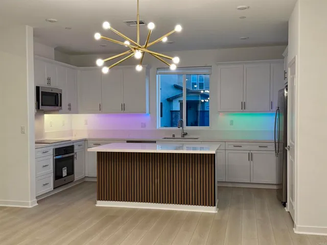 a large kitchen that has a lot of cabinets and a wooden floor