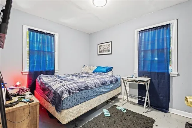 a bedroom with a bed and a chair in it