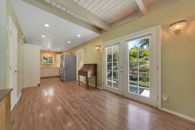 a view of an empty room with window and wooden floor