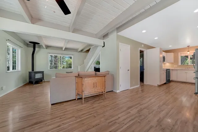 a view of a big room with wooden floor and windows