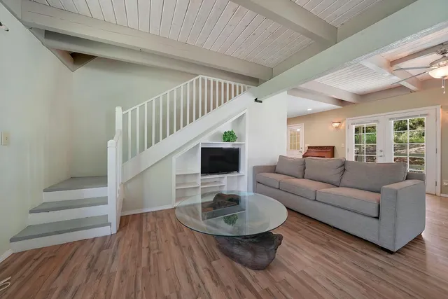 a living room with furniture and a wooden floor