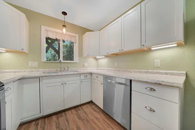 a kitchen with granite countertop white cabinets and white appliances