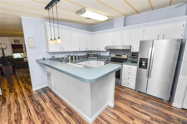 a kitchen with stainless steel appliances a stove top oven a sink dishwasher and a wooden cabinets