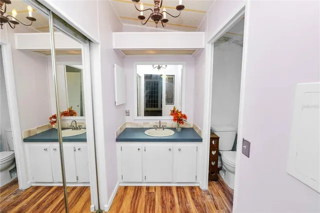 a bedroom with a bed dresser and a flat tv screen