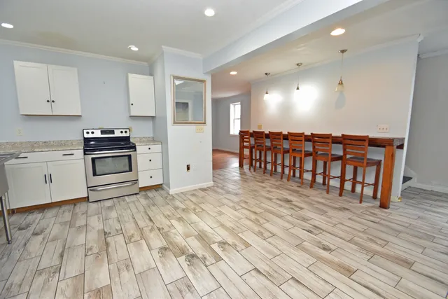 a kitchen with stainless steel appliances wooden floor and a refrigerator