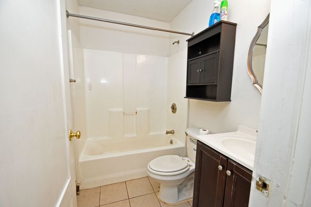 a bathroom with a bathtub shower sink mirror vanity and a toilet