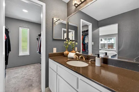 a bathroom with a sink double vanity granite and a mirror