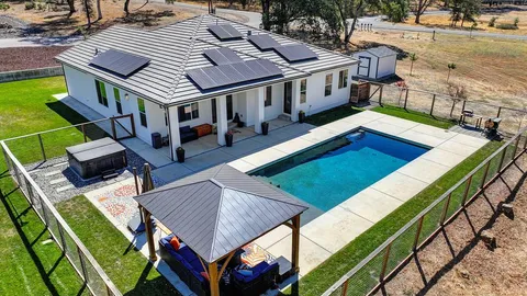 a aerial view of a house with pool and chairs