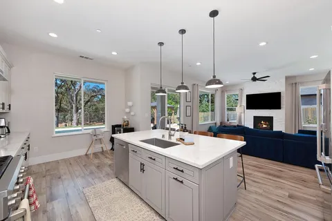 a kitchen with a sink stove and wooden floor