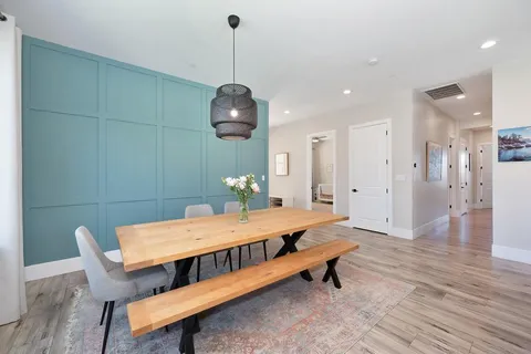 a room with a table chairs and wooden floor