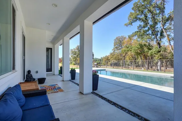 a view of swimming pool with outdoor seating and plants