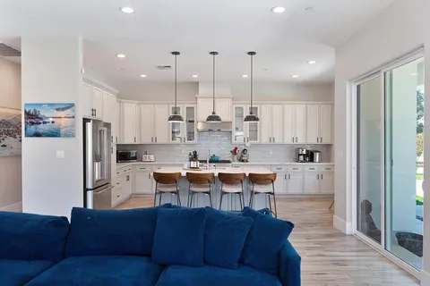 a view of kitchen with kitchen island stainless steel appliances refrigerator stove microwave and cabinets