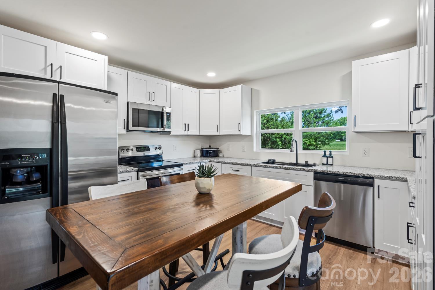 5740 Crouse Road Crouse, NC 28033 - Photo 1 of 28 a kitchen with a table chairs microwave and refrigerator