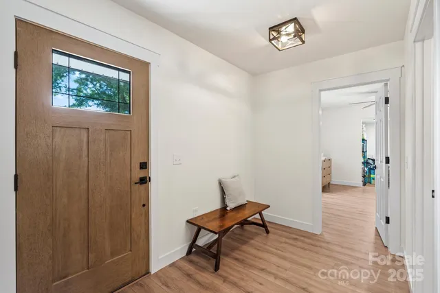 a view of a room with wooden floor a ceiling fan and windows