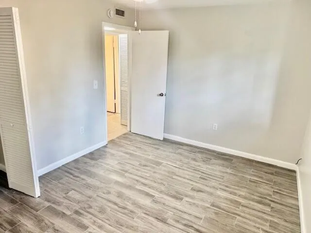 a view of a room with wooden floor and windows