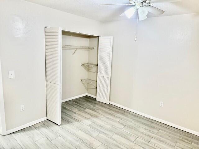 650 Southwest 2nd Avenue, Unit 253 Boca Raton, FL 33432 - Photo 28 of 32 an empty room with wooden floor chandelier fan and windows