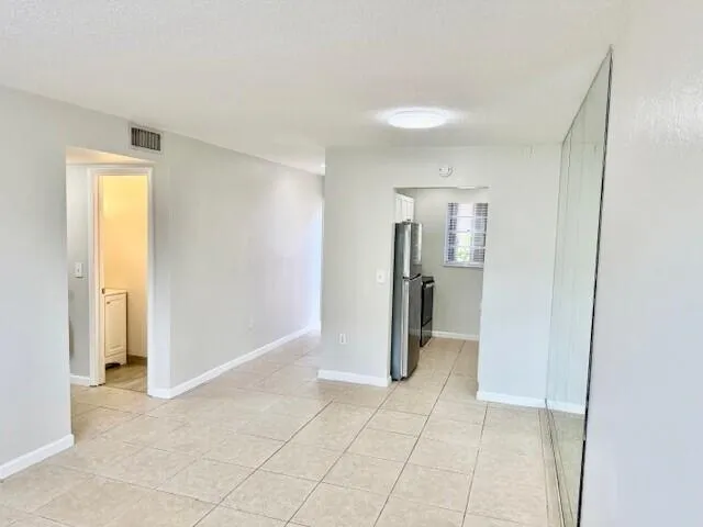 an empty room with cabinet and mirrors