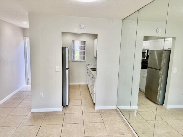 650 Southwest 2nd Avenue, Unit 253 Boca Raton, FL 33432 - Photo 6 of 32 a view of a refrigerator in kitchen and an empty room in wooden floor