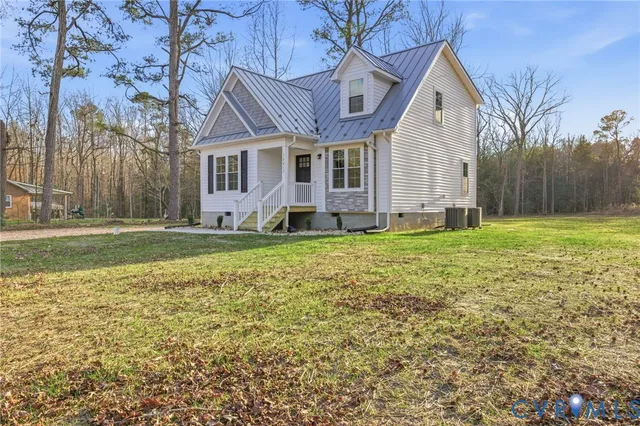 a front view of a house with a yard and trees