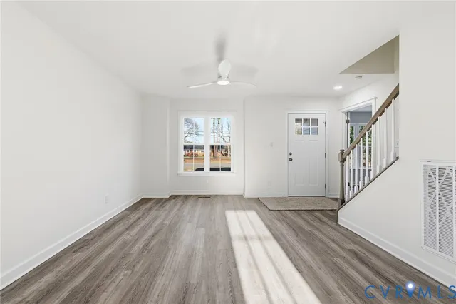 wooden floor in a hall with an entryway and a window