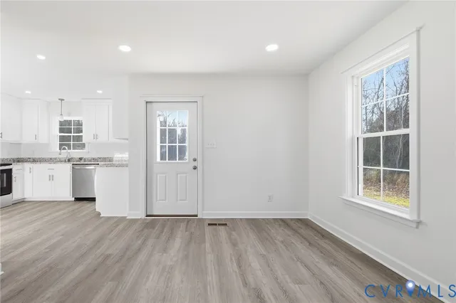 a view of a kitchen with wooden floor and windows