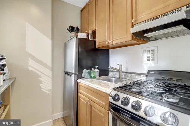 a kitchen with stainless steel appliances granite countertop a stove and a refrigerator