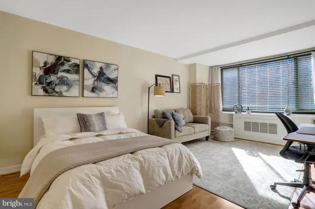 a bedroom with a bed a couch and a large window