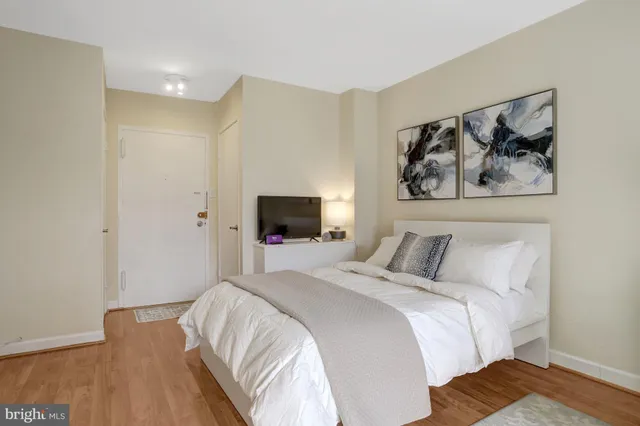 a bedroom with a bed and a wooden floor