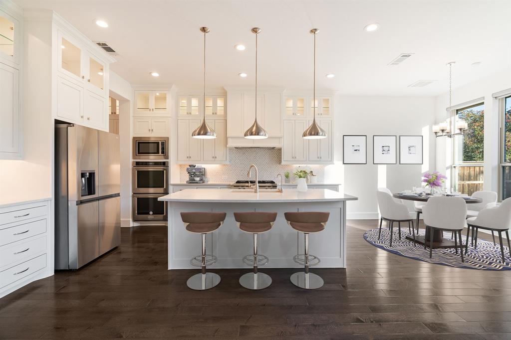 2441 Flat Creek Road Frisco, TX 75036 - Photo 10 of 34 a large kitchen with stainless steel appliances kitchen island granite countertop a large island in the center