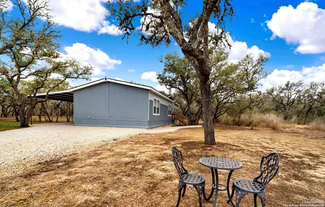 a backyard of a house with table and chairs