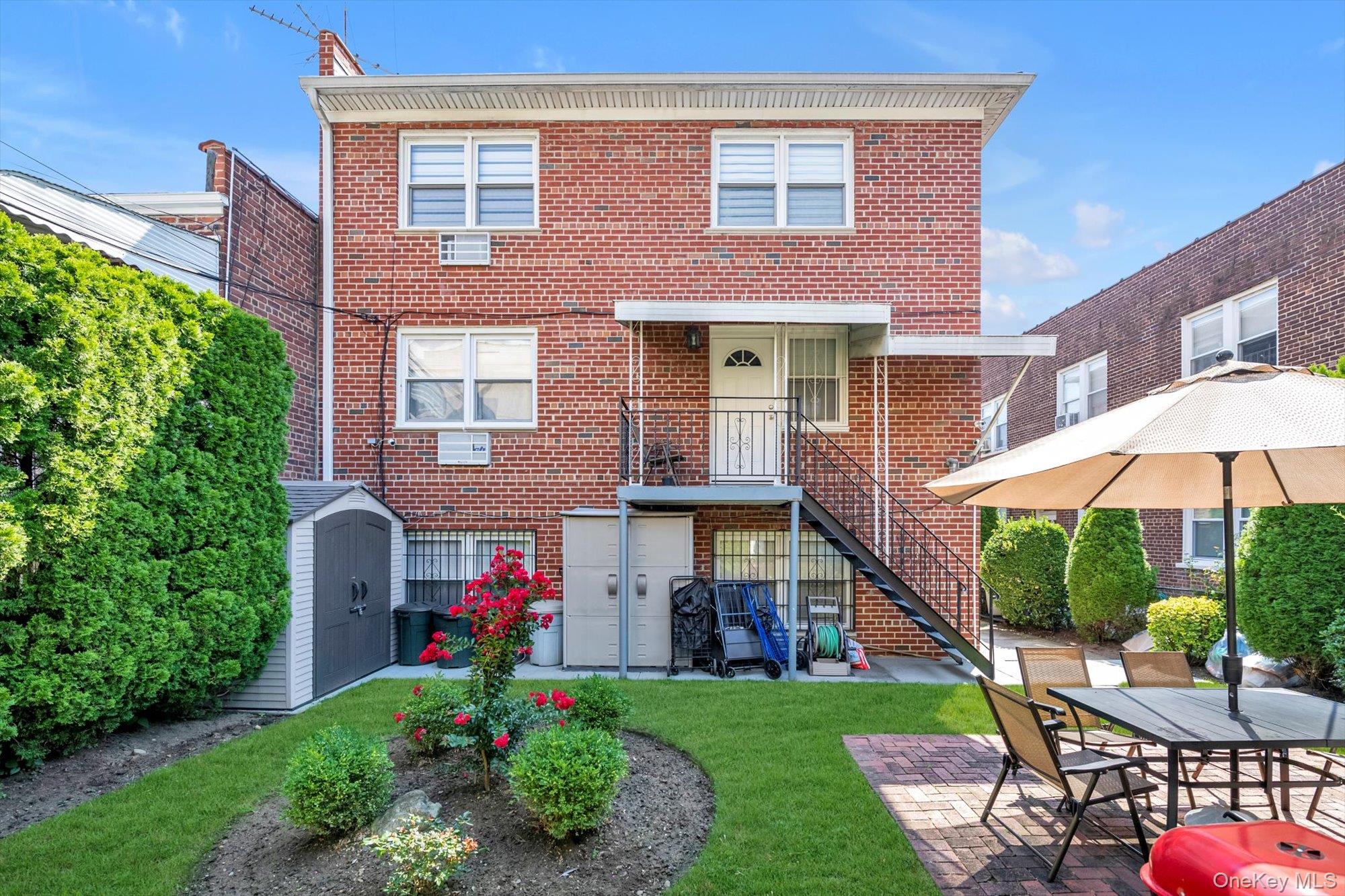 61-26 164th Street Queens, NY 11365 - Photo 12 of 17 a front view of house with yard and patio