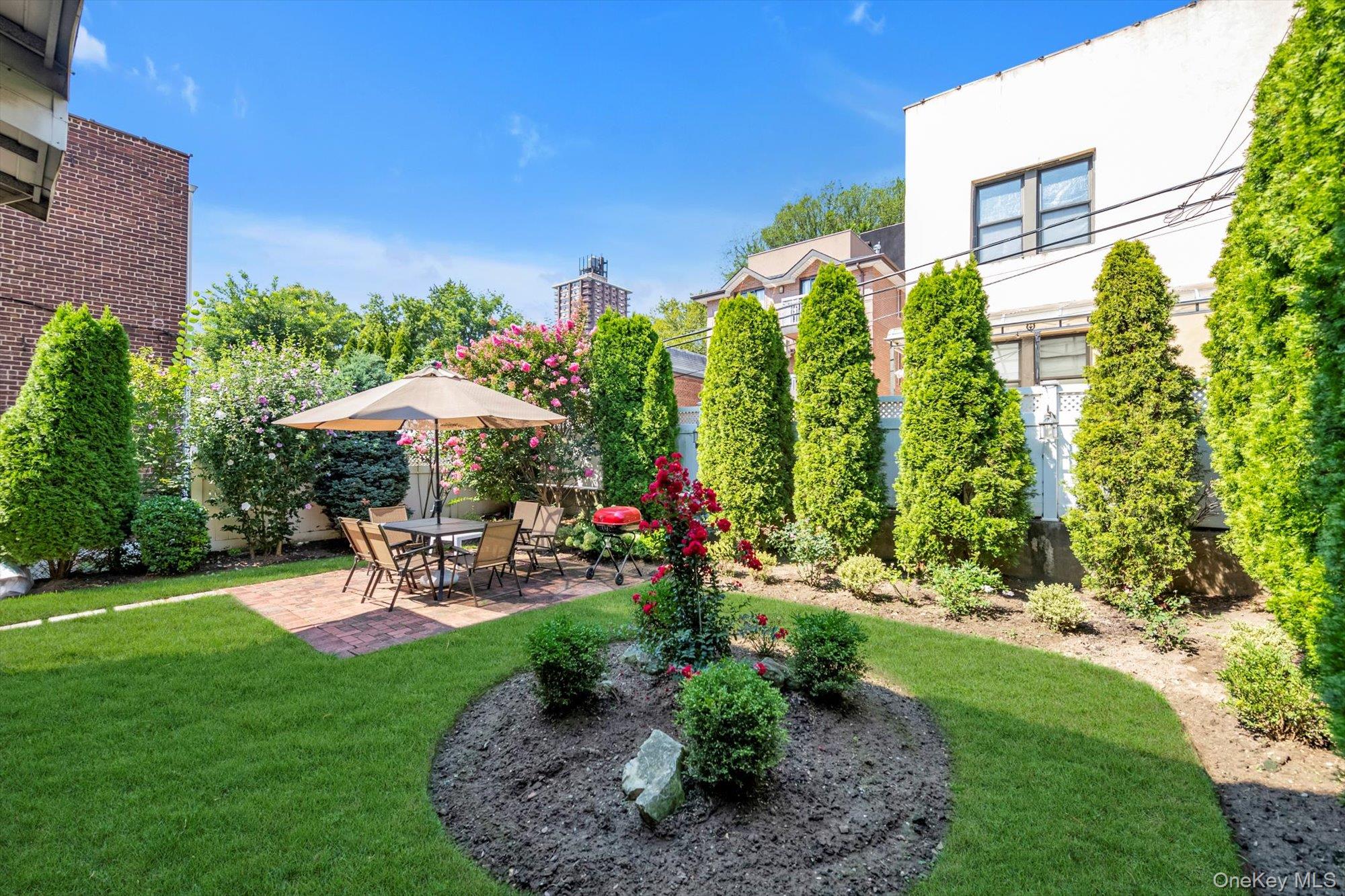61-26 164th Street Queens, NY 11365 - Photo 14 of 17 a view of a patio with table and chairs under an umbrella