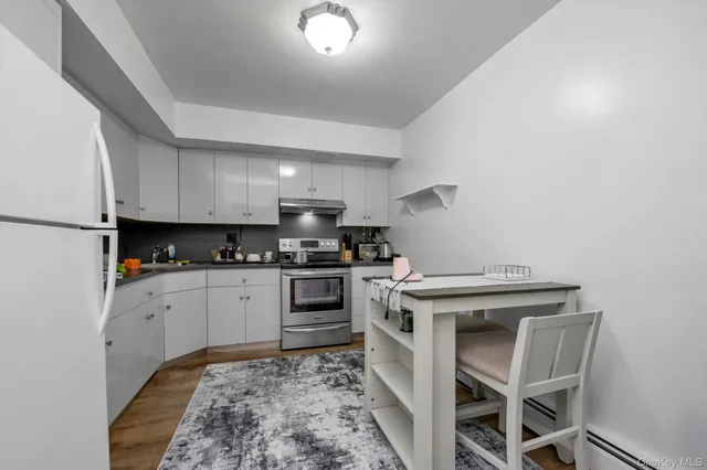 a kitchen with a stove and white cabinets