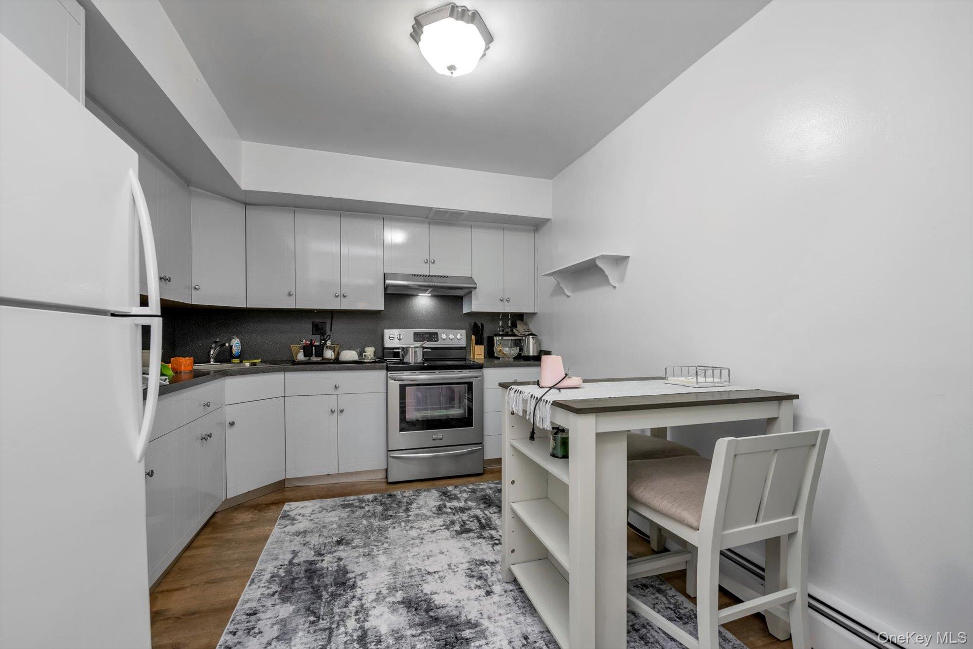 61-26 164th Street Queens, NY 11365 - Photo 7 of 17 a kitchen with a stove and white cabinets