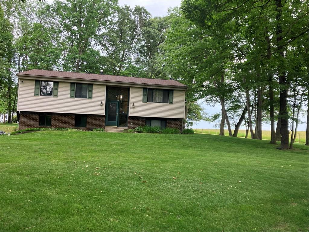 125 Beacon Road Renfrew, PA 16053 - Photo 1 of 31 a view of a house with a large tree and a yard