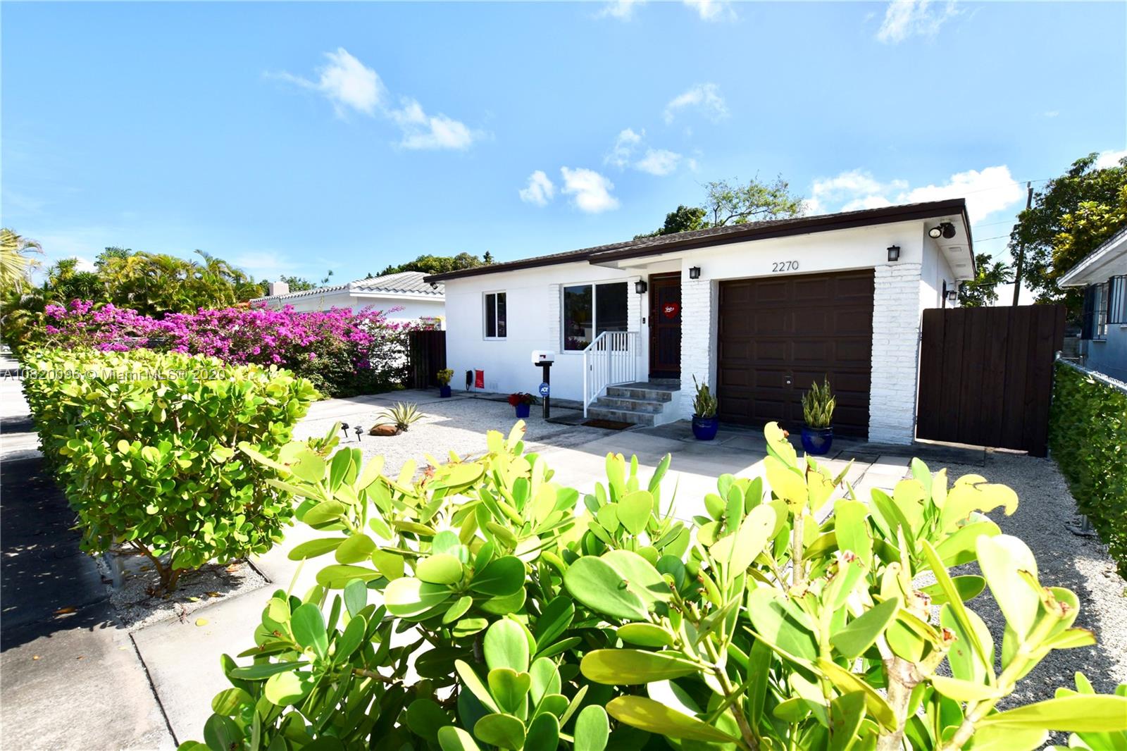 a front view of a house with a yard and a garden