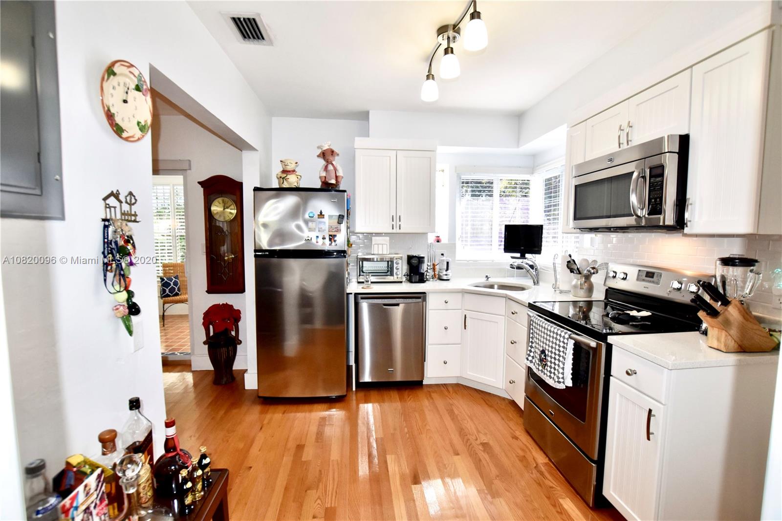 2270 Southwest 24th Street Miami, FL 33145 - Photo 7 of 22 a kitchen with stainless steel appliances a stove top oven a refrigerator a sink and dishwasher with white cabinets