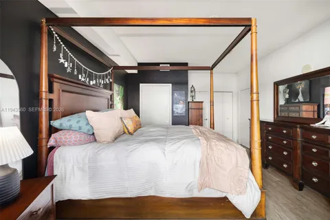 a bedroom with a bed and a lamp on dresser