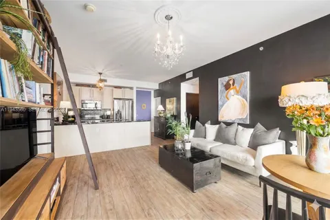 a living room with furniture and a chandelier