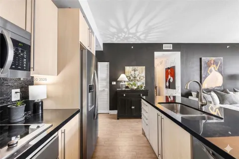 a kitchen with stainless steel appliances a sink and a refrigerator