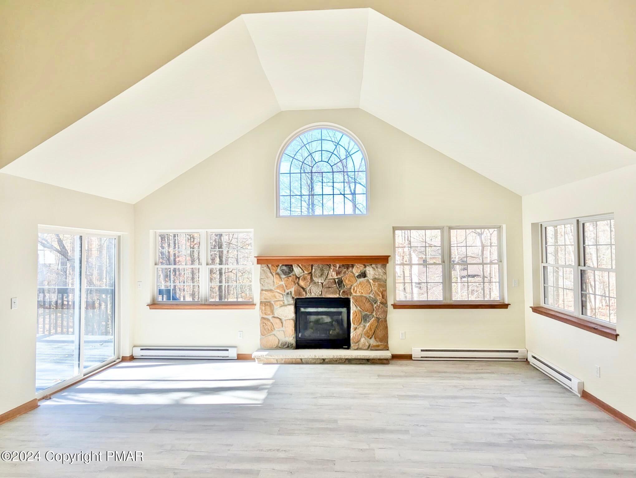 143 Cornwall Place Bushkill, PA 18324 - Photo 4 of 34 an empty room with wooden floor fireplace and windows