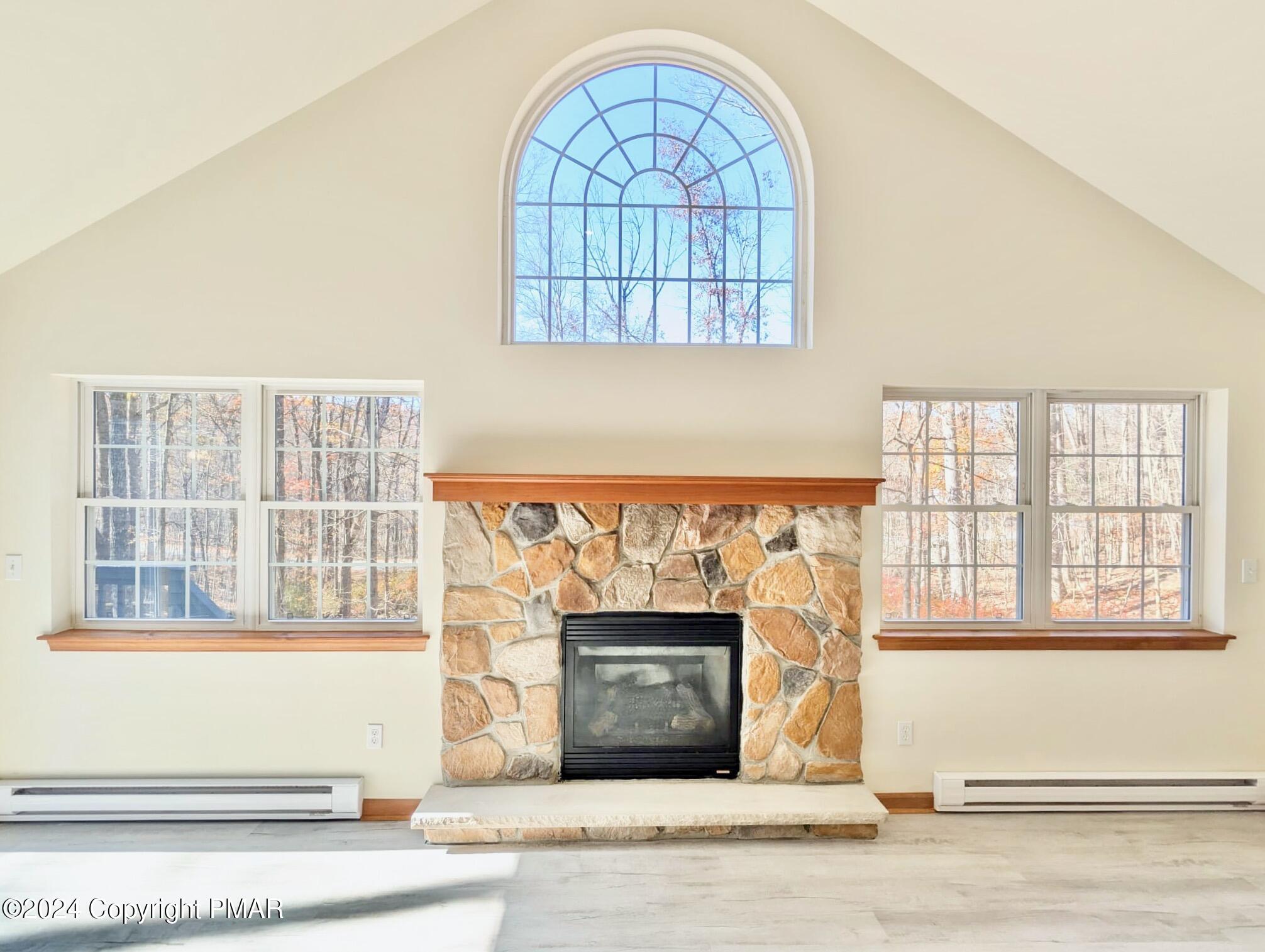 143 Cornwall Place Bushkill, PA 18324 - Photo 6 of 34 an empty room with wooden floor and a fireplace