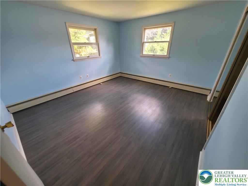 719 Keystone Avenue Bethlehem, PA 18018 - Photo 15 of 32 Two luminous windows frame a naturally illuminated bedroom with sleek wood flooring.