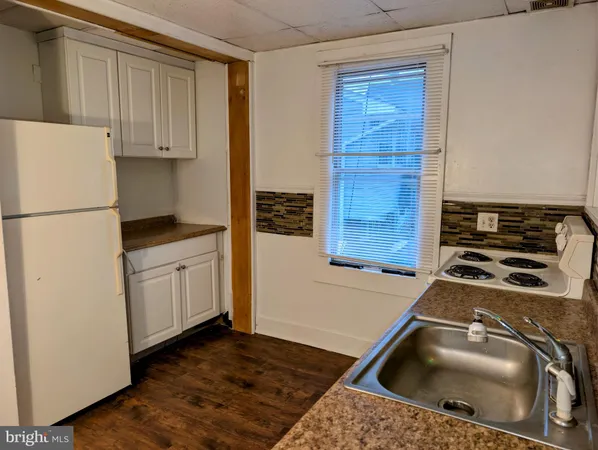 a kitchen with a refrigerator sink and cabinets