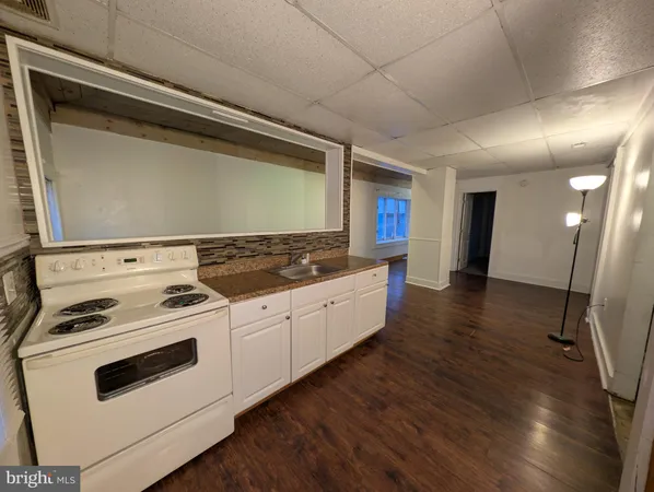 a kitchen with granite countertop wooden cabinets and white appliances
