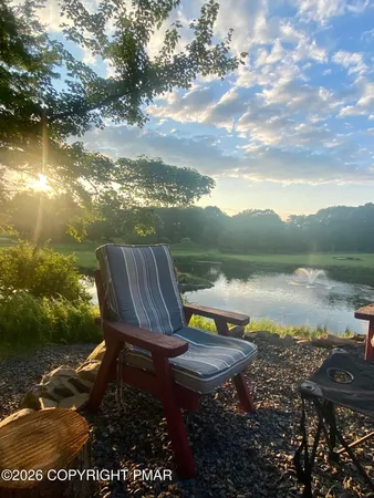 a view of a lake with lawn chairs and a table