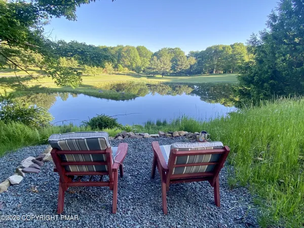 a view of a backyard with sitting area furniture and lake view