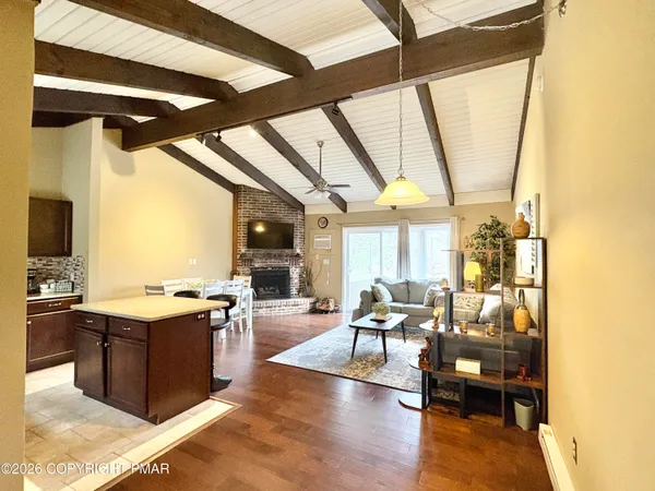 a living room with stainless steel appliances granite countertop furniture and a wooden floor