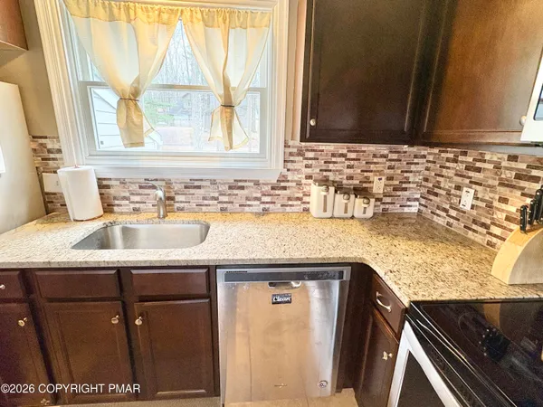 a sink with a granite countertop window and a sink